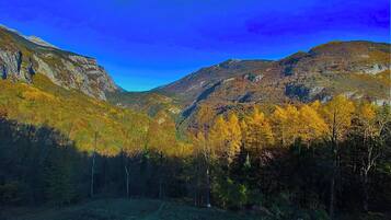 Un paysage montagneux aux couleurs automnales, sous un ciel dégagé.