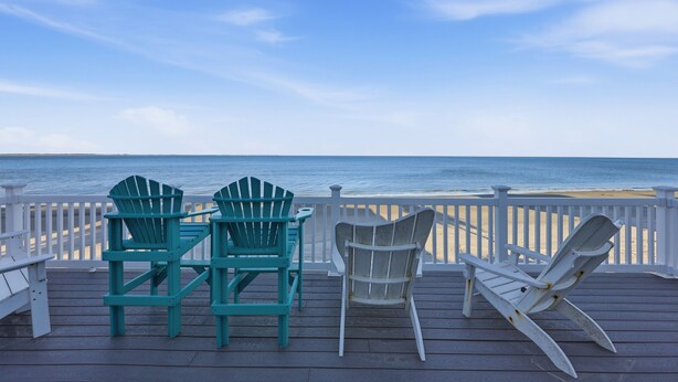 A wooden deck with Adirondack chairs overlooking the ocean. - Beachfront, Large Deck, Sleeps 9, Open, Airy & Spacious (Saint Helena Island)