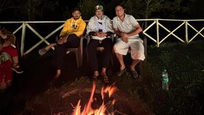 Un grupo de personas sentadas alrededor de una fogata por la noche.