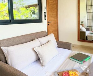 A bedroom with a bed, a laptop, and a book on the nightstand. - Penthouse Studio Apt w/ Private Roof & Pool ᯽PH8

 (Tulum)