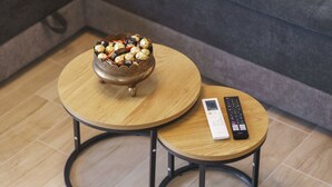 Two round wooden tables with metal frames, one with a bowl of chocolates and the other with a remote control. - Villa Tria Quercus (Vodice)