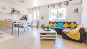 A modern living room with a sofa, coffee table, and dining area. - Holiday flat with air conditioning (Pula)