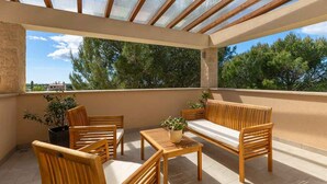 A sunlit outdoor patio with wooden furniture, a glass ceiling, and a view of trees and buildings. - Villa with pool, air conditioning, gym and parking (Vodnjan)