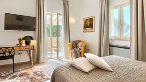 A bedroom with a bed, a desk, a chair, a TV, and a painting. - Villa with pool, air conditioning, gym and parking (Vodnjan)