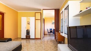 Una habitación de hotel con cama, televisión, escritorio y silla.