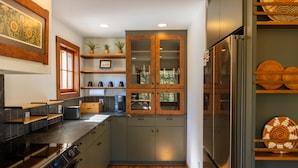 A modern kitchen with a built-in oven, stainless steel appliances, wooden cabinets, and a large refrigerator. - Serene Mountain View Cabin w/ Deck, Hot Tub, Fire Pit, Forest & Peak Retreats (Cascade-Chipita Park)