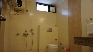A small, compact bathroom with a toilet, a shower, and a sink. - Design galleries complex (Faridabad)