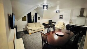 A compact living space with a dining area, kitchenette, and a sofa. - 1 Luxe Exec Bedroom Apt Derby (Derby)