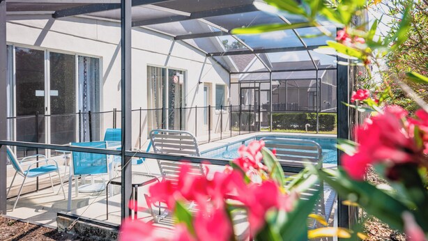 A covered outdoor area with a pool, chairs, and a glass enclosure. - 'Sunshine State of Mind' South Facing Pool & Spa (Clermont)