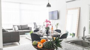 A modern living room with a grey sofa, a dining table set with chairs, and a fruit bowl on a marble countertop. - Luxury 2 bedroom apt free parking and Pool (Panamá)