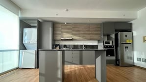 Una cocina moderna con armarios grises, una isla central y electrodomésticos integrados.