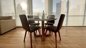 Un comedor con una mesa redonda, cuatro sillas y una botella de agua.