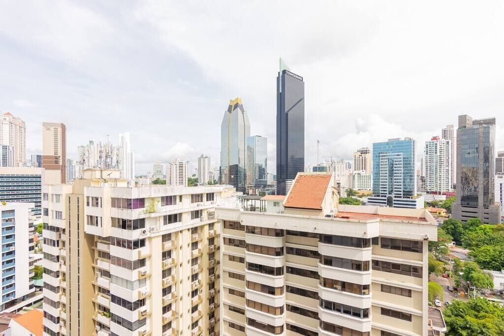 A cityscape with modern high-rise buildings, including a prominent skyscraper with a unique design.