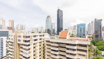 A cityscape with modern high-rise buildings, including a prominent skyscraper with a unique design.