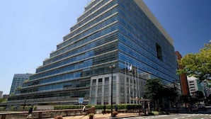 Ein modernes Hochhaus mit Glasfassade, mehreren Stockwerken und flachem Dach.