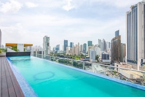A rooftop infinity pool with a city skyline view.