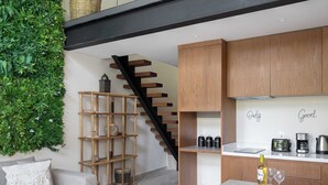 A modern kitchen with wooden cabinets, a built-in stove, and a hanging light fixture. - Moderno Loft Temple II A112 By Sandy Powerful (Tulum)