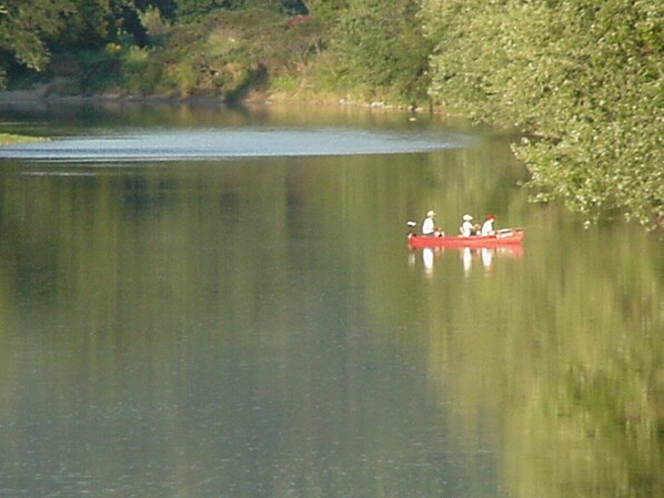 A calm lake with a red canoe carrying two people.