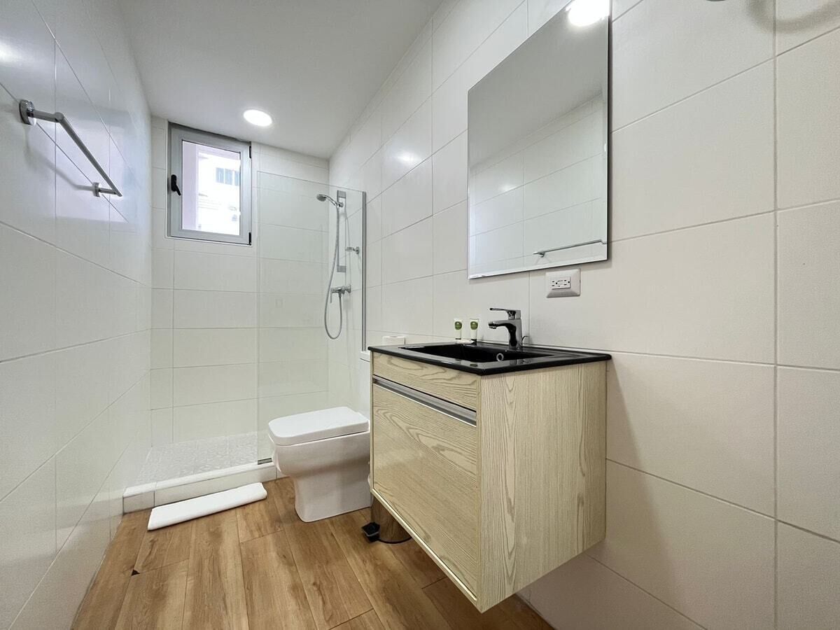 Un baño moderno con ducha, inodoro y tocador.