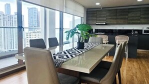 Un comedor moderno con una mesa grande, sillas y una planta en maceta.