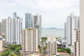 Un ensemble immobilier résidentiel de grande hauteur, composé de plusieurs immeubles d’appartements, offrant une vue sur la mer et sur un pont situé au loin.
