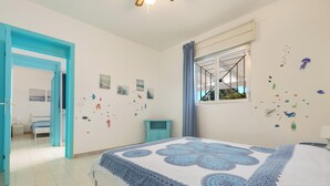 A bedroom with a bed, a window with curtains, and wall decorations including fish and plant stickers. - Villa Mormora by BarbarHouse (Padula Fede)