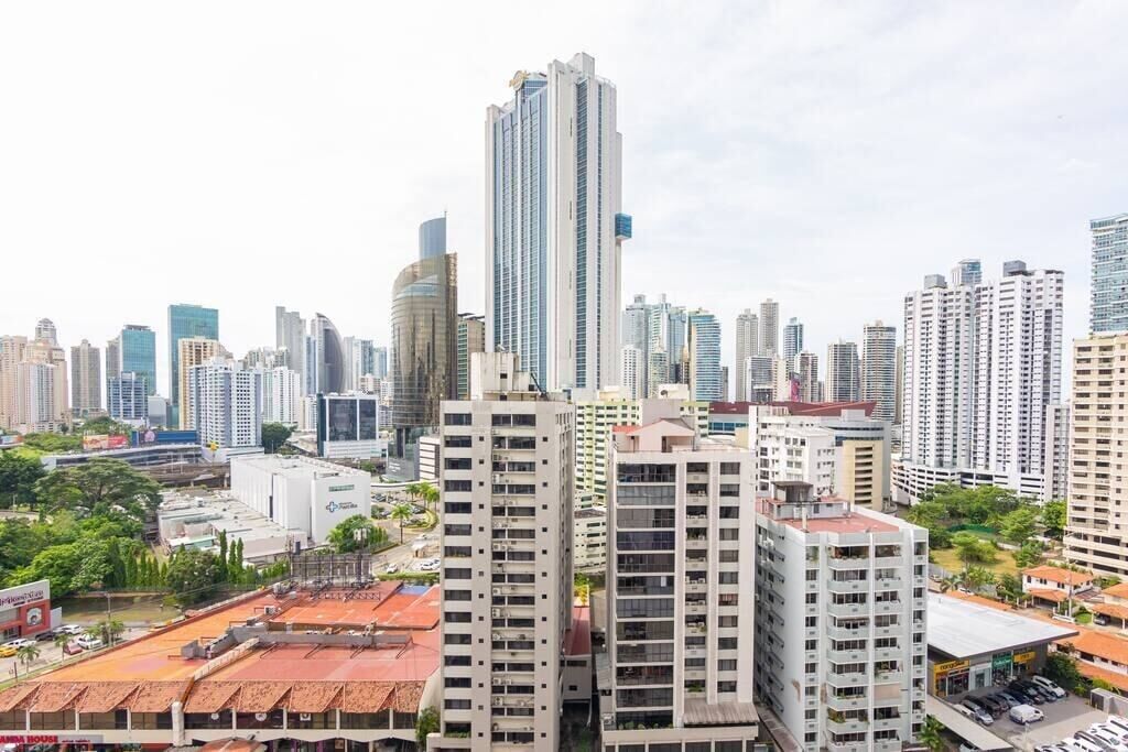 A high-rise building with a modern design, surrounded by other tall buildings in a cityscape.