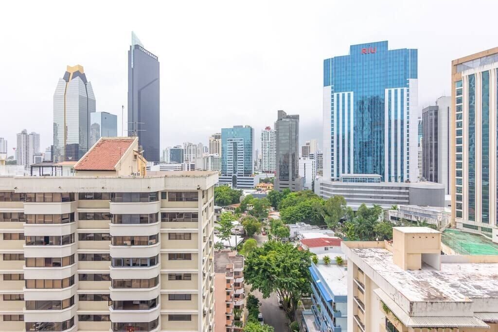 A cityscape with modern high-rise buildings, including a prominent blue glass building with the 'RIV' logo.