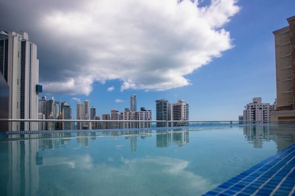 A rooftop infinity pool with a city skyline view.