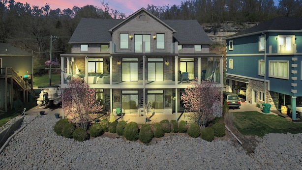 A two-story house with a balcony, a garage, and a driveway. - Beautiful views and sunrises overlooking the water. Spacious home with elevator. (Jeffersonville)