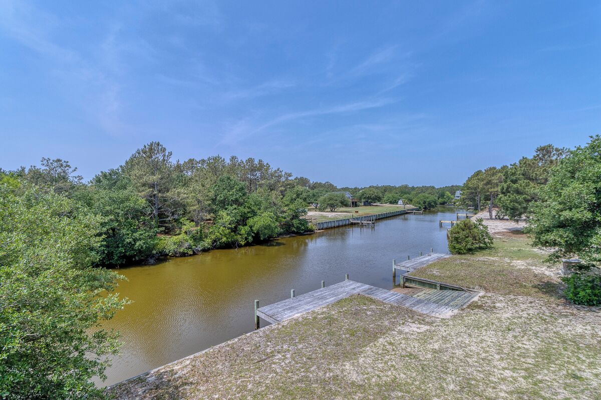 Une rivière avec un quai et des berges verdoyantes.