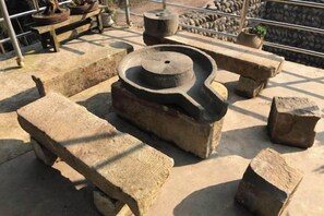 A stone structure with a circular basin, possibly a fountain, surrounded by stone benches. - Mount Emei Feng Lin Yue Hotel (Emeishan City)