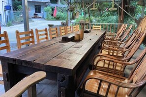 A long wooden table with chairs, a small table lamp, and a wooden block. - Mount Emei Feng Lin Yue Hotel (Emeishan City)
