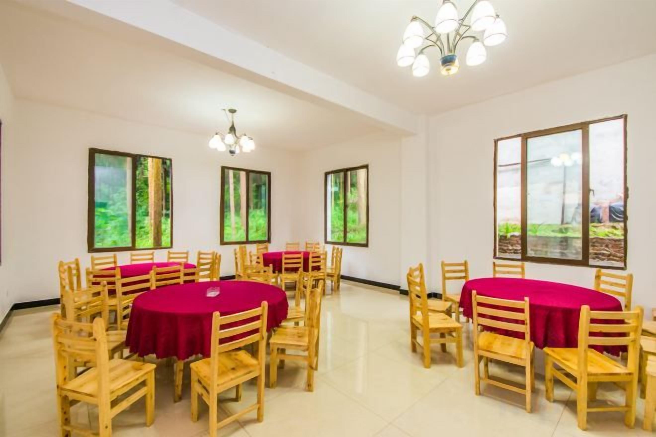 A conference room with round tables, chairs, and large windows with a view.