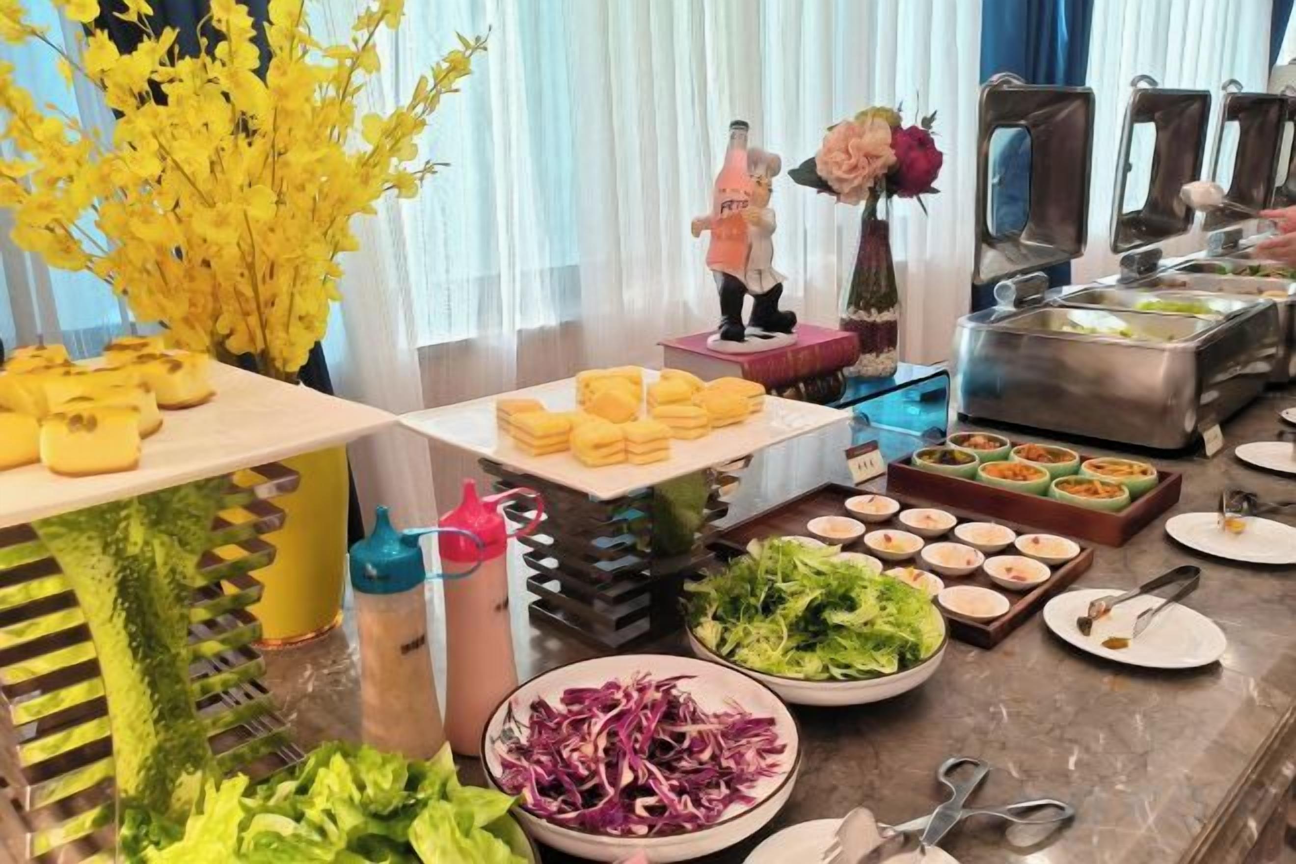A buffet setup with various food items and utensils.