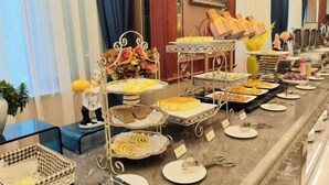 Montaje tipo bufé con diferentes alimentos y una estatua decorativa.