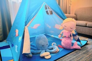 A blue tent with a window, a plush octopus, and a mermaid doll on a mat. - Huaxia Conifer Hotel (Dazhou)