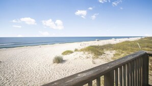 Una playa con un paseo marítimo de madera que llega hasta la orilla.