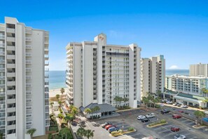 Un hôtel de grande hauteur doté de nombreux balcons, d’un parking et offrant une vue sur l’océan.