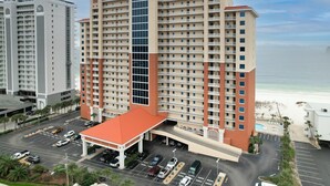 A high-rise hotel with multiple floors, a central atrium, and a parking lot.