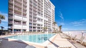 A hotel with a large pool, multiple balconies, and outdoor seating areas. - Pelican Pointe 1505 (Orange Beach)