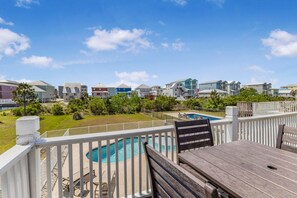A residential area with a pool, white fences, and colorful houses.