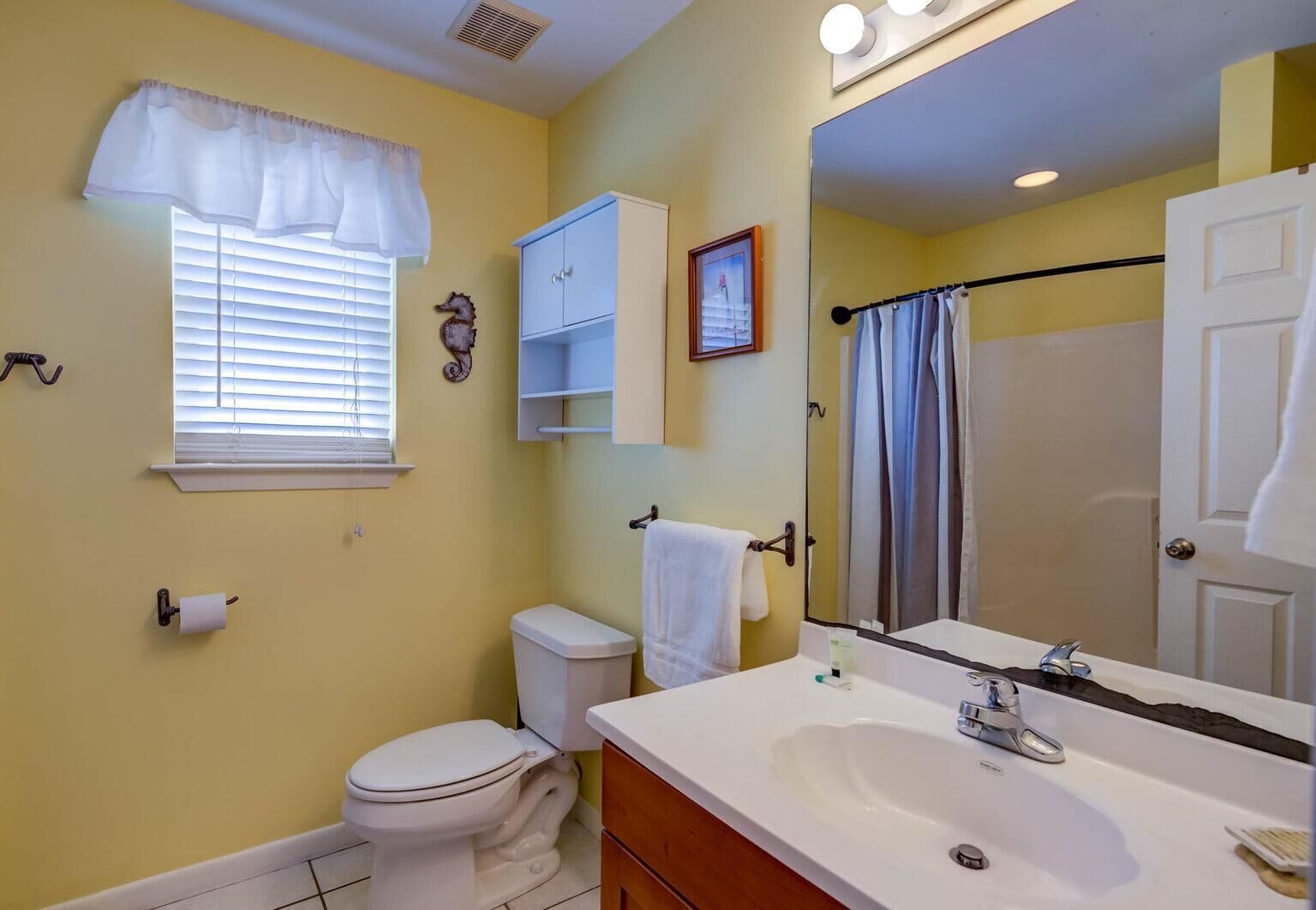 A bathroom with a toilet, sink, and shower.