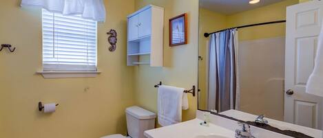 A bathroom with a toilet, sink, and shower.