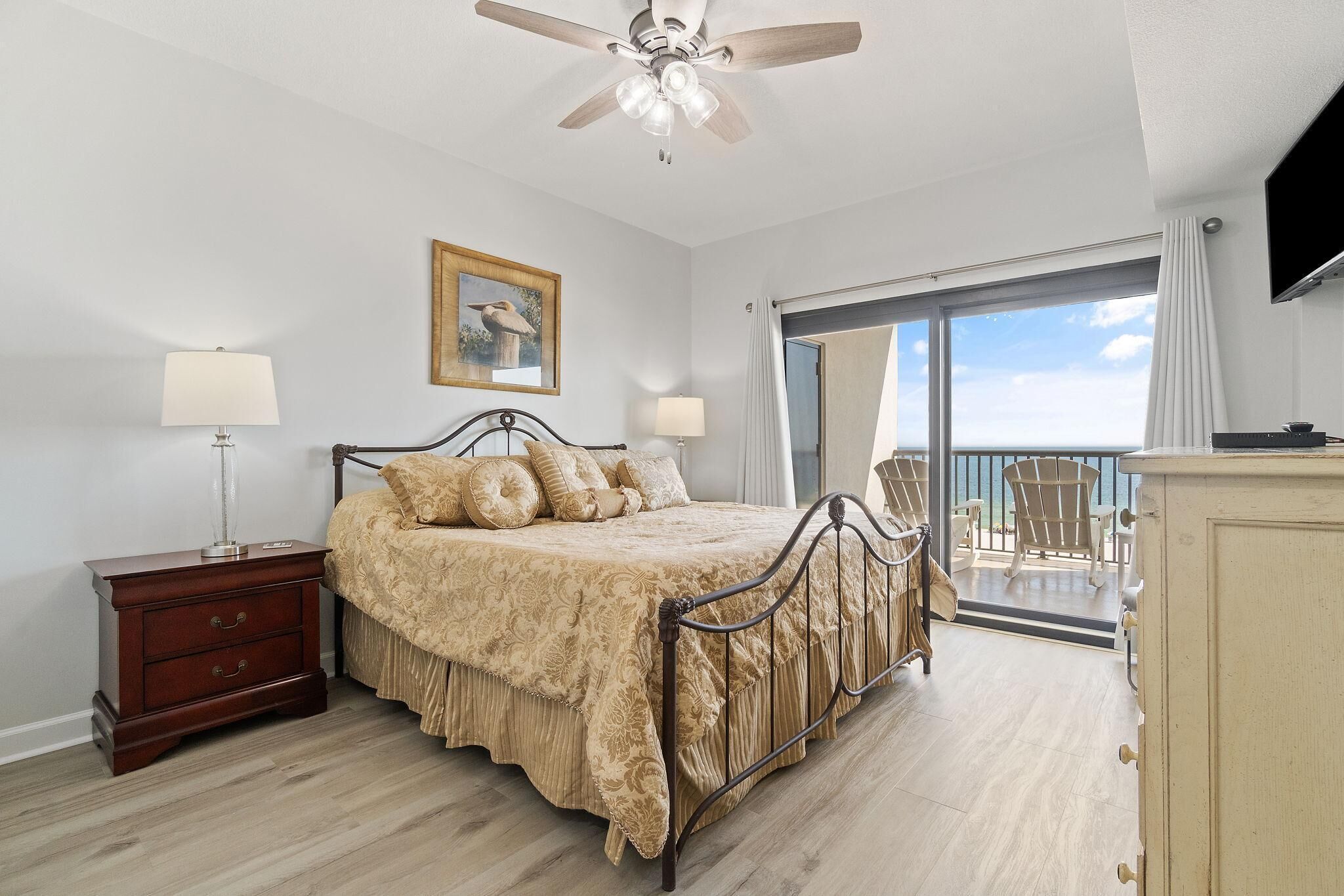 A bedroom with a bed, nightstand, and a ceiling fan.