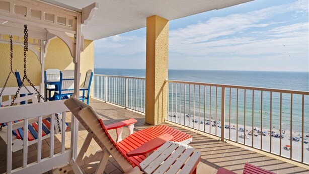 A balcony with a view of the beach, white and red lounge chairs, and a white railing. - Summer House 1405a (Orange Beach)