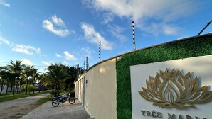 Un camino pavimentado que conduce a un edificio con un letrero que dice "Tres Maria Pousada Boutique".