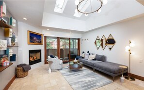 Ein modernes Wohnzimmer mit Kamin, einer Couch, einem Couchtisch und einer Stehlampe.