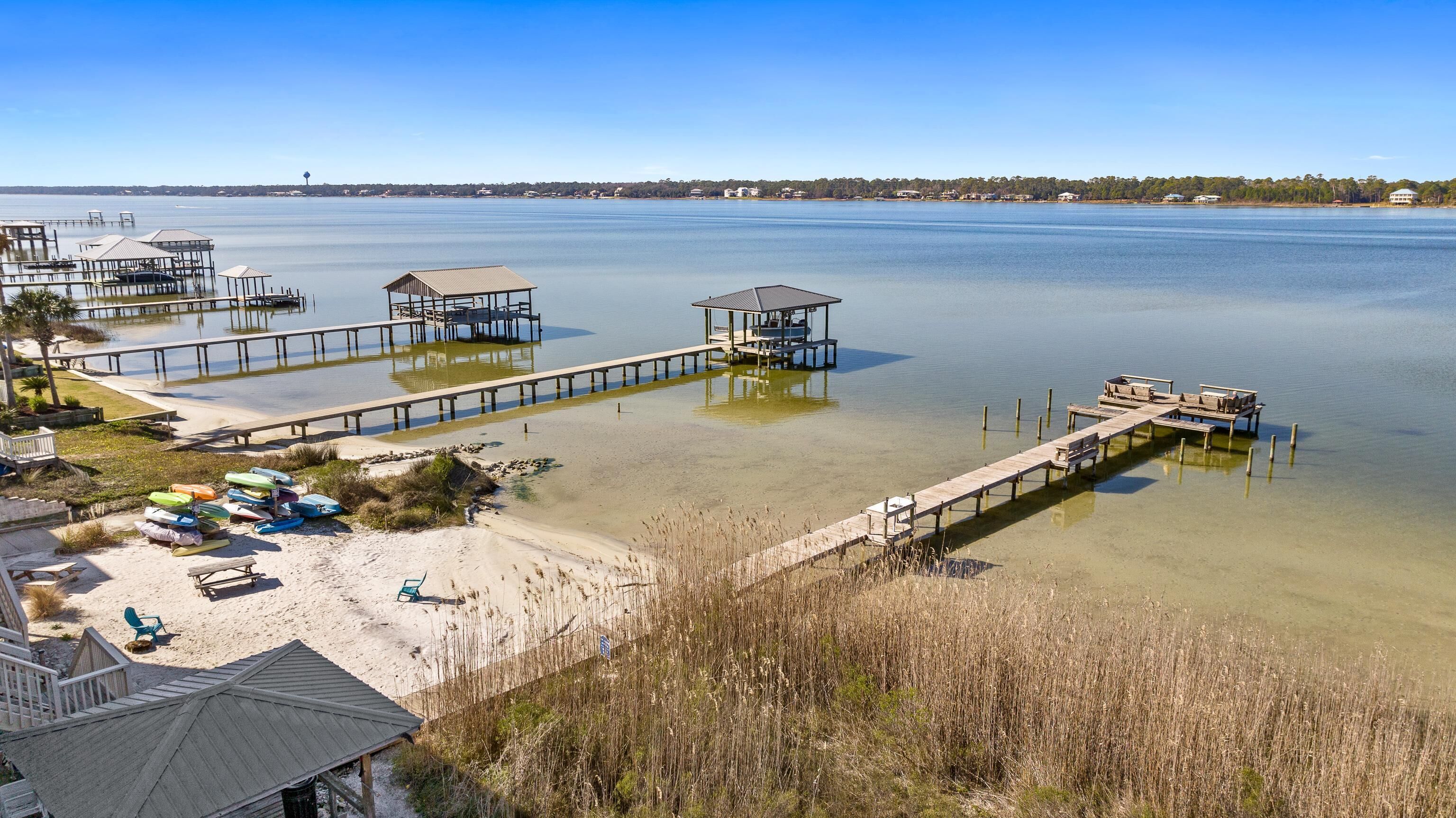 A coastal area with multiple piers extending into calm waters, surrounded by sandy beaches and sparse vegetation.
