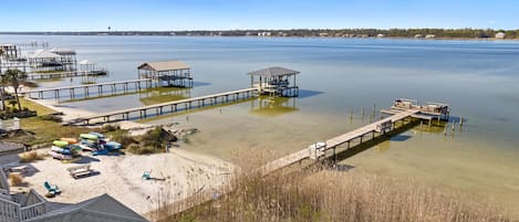 A coastal area with multiple piers extending into calm waters, surrounded by sandy beaches and sparse vegetation.